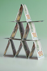US dollar bills lined up in pyramid on the green background