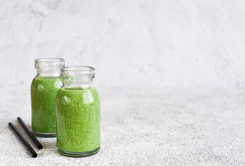 Detox menu. Smoothie with spinach on a concrete background in a jar.