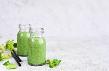 Detox menu. Smoothie with spinach on a concrete background in a jar.