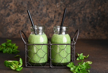 Detox menu. Vegetable smoothie with spinach on a dark concrete background in a jar.