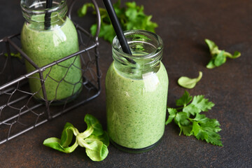 Detox menu. Vegetable smoothie with spinach on a dark concrete background in a jar.