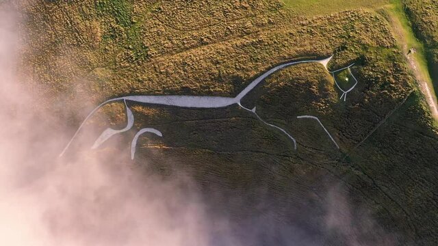 4k rising birds-eye footage of Uffington White Horse in Oxfordshire. The Uffington White Horse is a prehistoric hill figure, 110 m long, formed from deep trenches filled with crushed white chalk.
