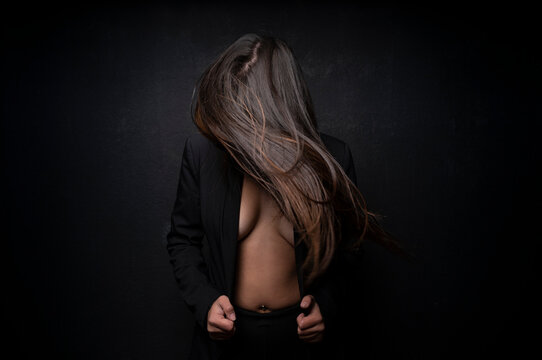 Young beautiful woman shacking hair in black background