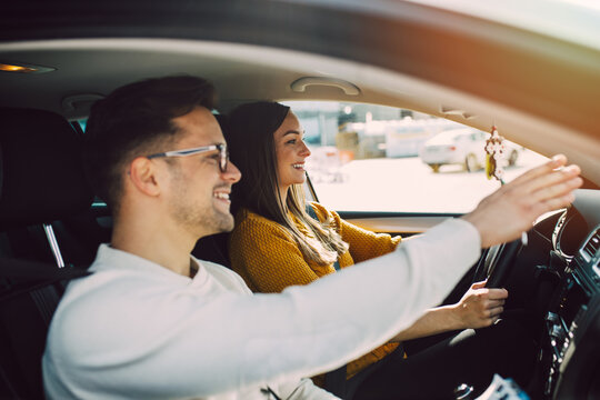 Driving school or test. Beautiful young pregnant woman learning how to drive car together with her instructor.