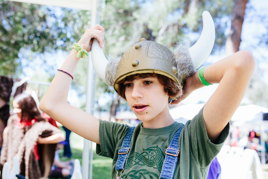 Young teen girl tries on a plastic Viking helmet