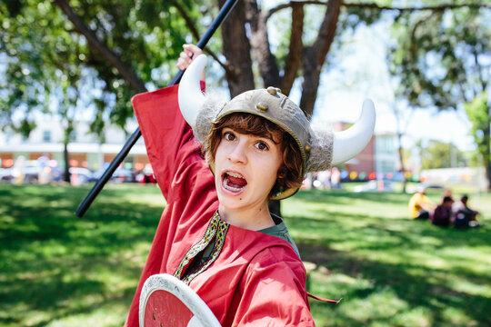 Young teen girl gets in character as a Viking warrior while dressed up