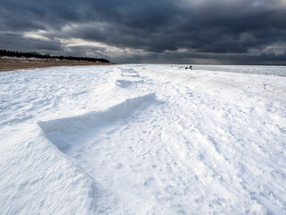 Fototapeta na wymiar Frozen sea with snow and shoreline. Abstract snow formations.