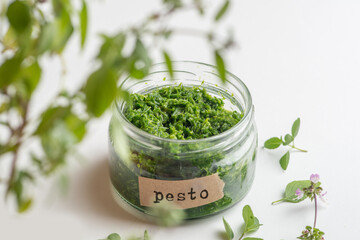 pesto sauce in a jar with a signed label on a white background