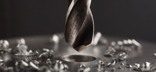 metal drill bit make holes in steel billet on industrial drilling machine. Metal work industry....