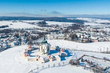 Aerial drone view of Pilgrimage Church of Saint John of Nepomuk, Zdar nad Sazavou, Czech Republic. UNESCO heritage. Ancient monastery at Zelena Hora hill. Winter weather with snow, blue sky.