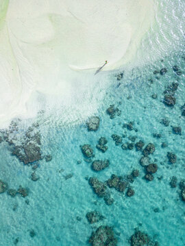 A girl is walking on a beach in Cook Islands