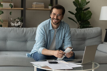 Happy young male distracted of studying terms conditions of credit documents look aside plan loan...