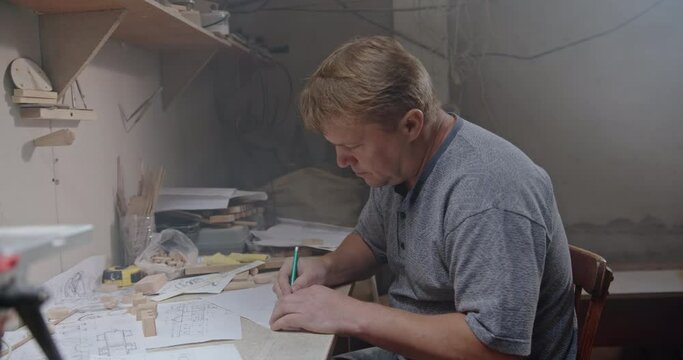 Creative process of creating a new wood product for your own startup business. The creative master carpenter in the workshop on wood is thinking about a new project.