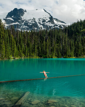 A girl does a belly flop into the vibrant blue Joffre Lakes.