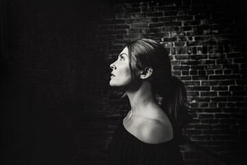 Young woman in profile with shoulders showing looking up at the light