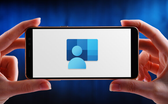 Hands holding smartphone displaying logo of Microsoft Intune