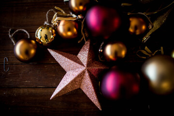 red and gold christmas ornaments on dark wood table, flat lay
