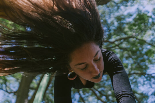 Aerial Silks Performer Hanging On A Tree With Head Down