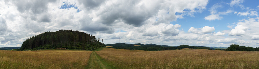 Panorama of eifel landscape with Nerother mountain and fields over cloudy sky ,Germany, Neroth