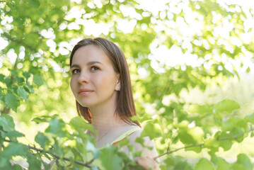 portrait of a young beautiful woman on a background of green leaves copy space. the concept of health, freshness and youth