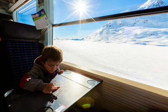 Child playing on Bernina Express train, Engadin, Switzerland