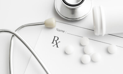Prescription pills on prescription Rx paper with medical stethoscope