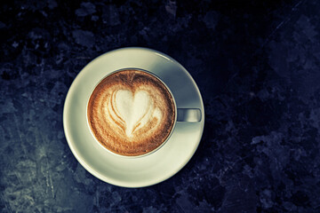 Top view of cup of cappuccino on the table. Morning coffee. Hipster cafe concept. Vintage coffee.