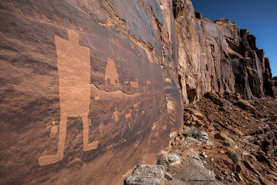 Native American petroglyphs etched into sandstone rock.