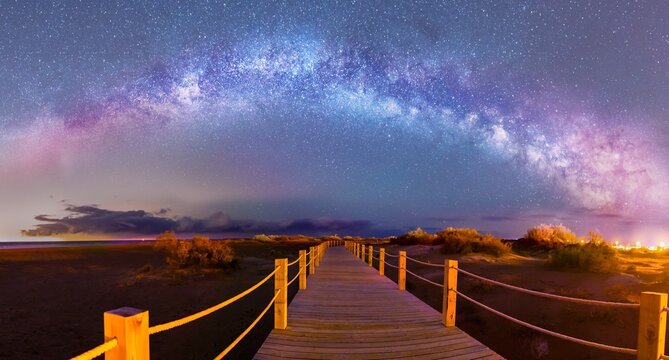 Milky Way Arch over a woden path in Riumar Beach, Catalonia, Spain
