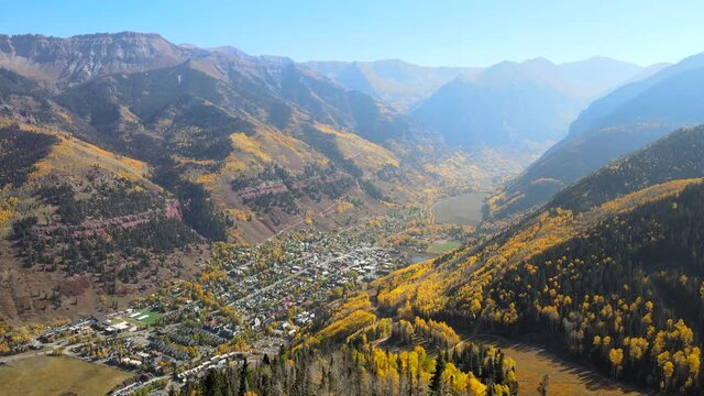 Aerial 4K video of the picturesque town of Telluride, Colorado on a sunny autumn day with yellow aspens