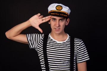 Handsome guy on a black background. Captain of a sea vessel. Positive and negative emotions.