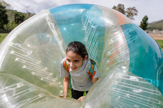 Tween girl smiles while inside a bubble soccer bubble suit