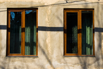Windows and green curtain, house facade and sunlight