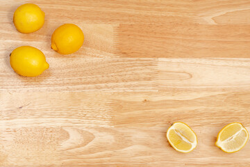 whole lemons and cut lemons on a wooden table