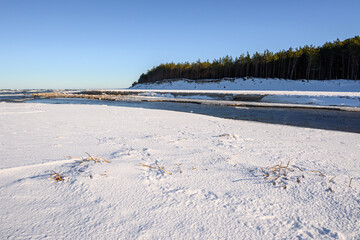 Fototapeta na wymiar Snow covered beach on the Baltic Sea. Piasnica River, Debki, Poland