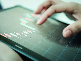 Businessman checking stock market dataมStock Market Application for Mobile, Analyzing Data Stock Market on Mobile Young Businessman with Smartphone and Stock Market Chart Background.