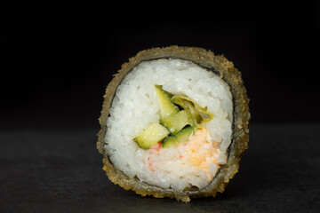Close up one Hot fried Sushi Roll on black background.Breaded Sushi