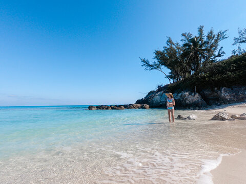 Adolescent Girl standing in the clear Bahamas water wearing a swimsuit