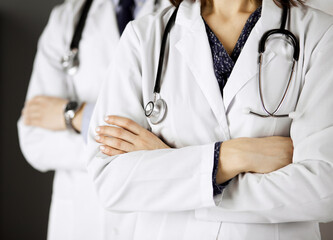 Group of modern doctors standing as a team with arms crossed in hospital office and ready to help patients. Medical help, insurance in health care, best disease treatment and medicine concept