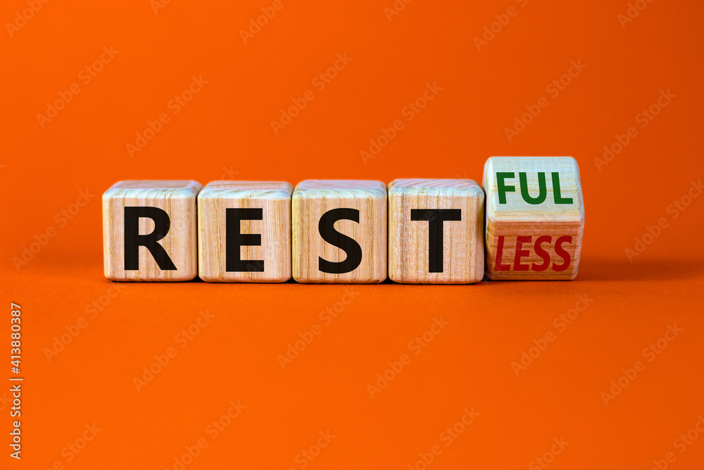 Fototapete Restless or restful symbol. Turned the wooden cube, changed the word 'restless' to 'restful'. Beautiful orange table, orange background, copy space. Business and restless or restful concept.