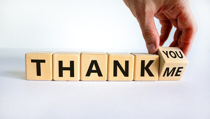 Thank you or me symbol. Businessman turns a cube and changes words 'thank me' to 'thank you'. Beautiful white background, copy space. Business, psychology and thank you or me concept.