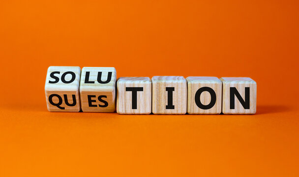 Question and solution symbol. Turned wooden cubes and changed the word 'question' to 'solution'. Beautiful orange table, orange background, copy space. Business, question and solution concept.