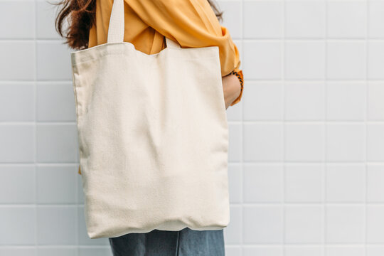 Woman is holding tote bag canvas fabric for mockup blank template.