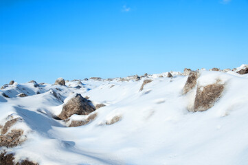 Winter landscape in the afternoon outdoors in mountains against the blue sky.