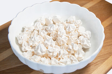 Delicious appetizing Meringue Pavlovas in a Bowl. Homemade meringues. French dessert, sweet food made by baking a mixture of stiffly beaten egg whites and sugar until crisp. German Baiser