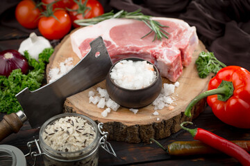Raw meat with spices in a composition with kitchen accessories.