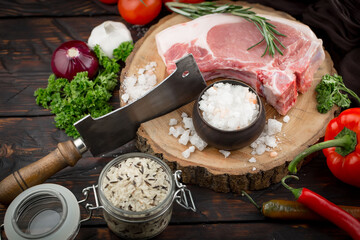 Raw meat with spices in a composition with kitchen accessories.