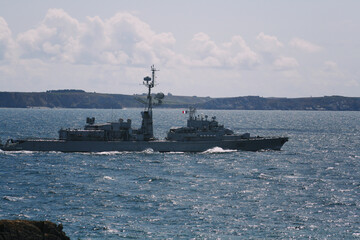 French warship plies the ocean with coast in the background © karzof pleine