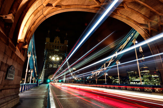 Light trails on Tower Bridge in city against sky at night
