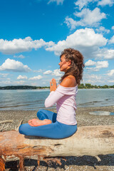 Fototapeta na wymiar healthy lifestyle young woman meditate on fresh air on river beach sunny summer day